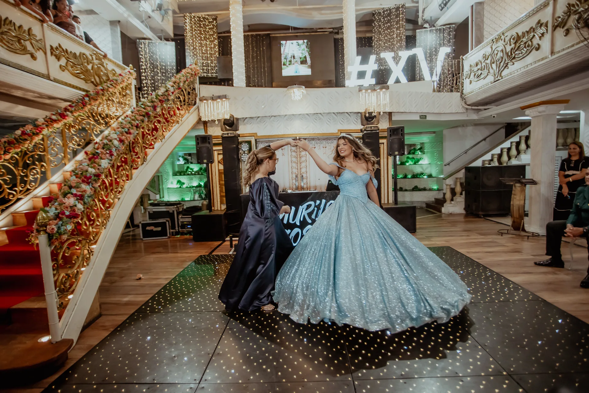 Debutante de vestido azul dançando acompanhada no salão Palace Hall